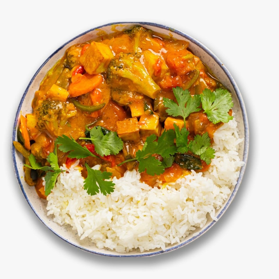 Indian vegetable curry with broccoli, carrots, and tofu, served with white rice and cilantro.